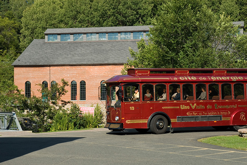 L'autobus de style tramway s'apprête à descendre des visiteurs au secteur historique.