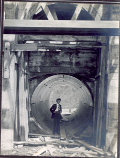 A man dressed in his Sunday best posing inside a penstock