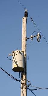 Photo of a transformer at the top of a distribution pole